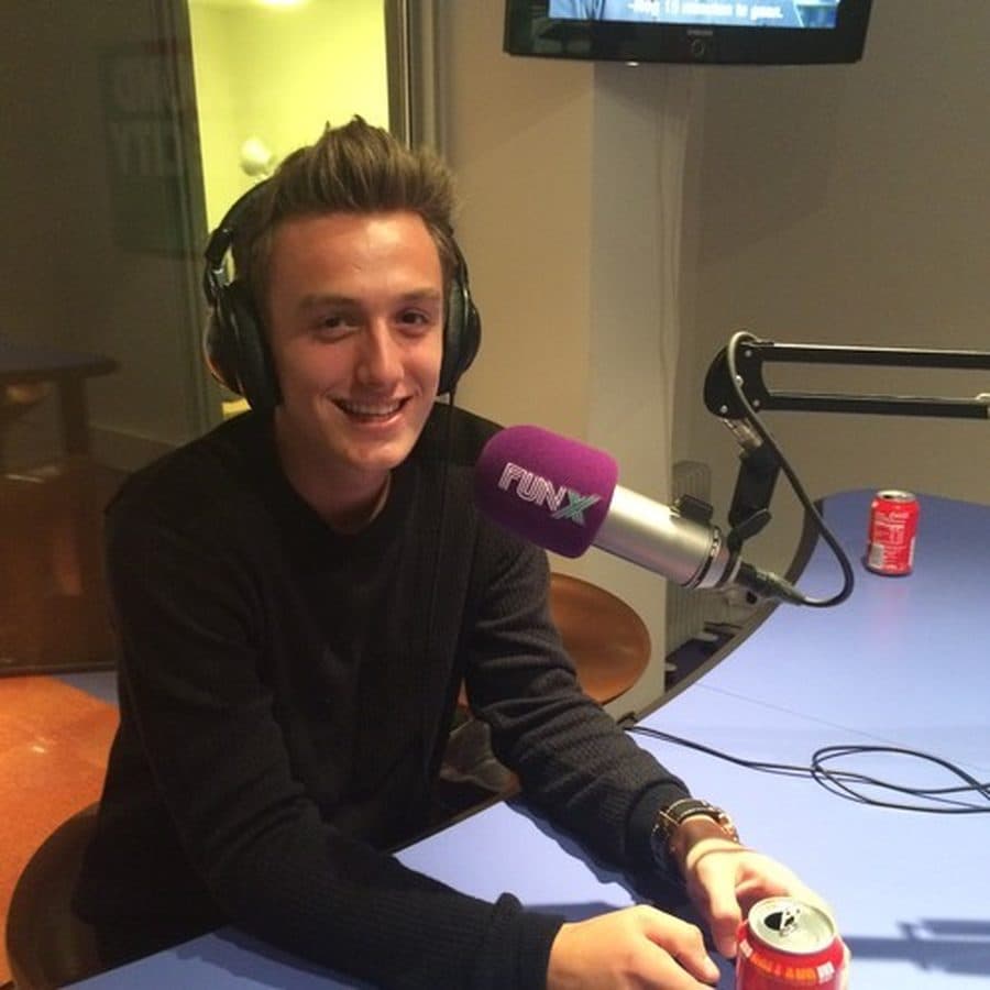 A young Ivo Adelaar smiling with headphones on behind a FunX microphone during an early radio interview