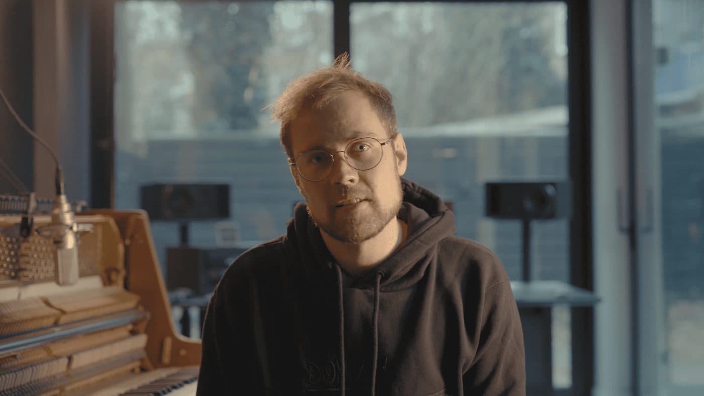A pianist beside the opened piano, on camera for MasterPiano